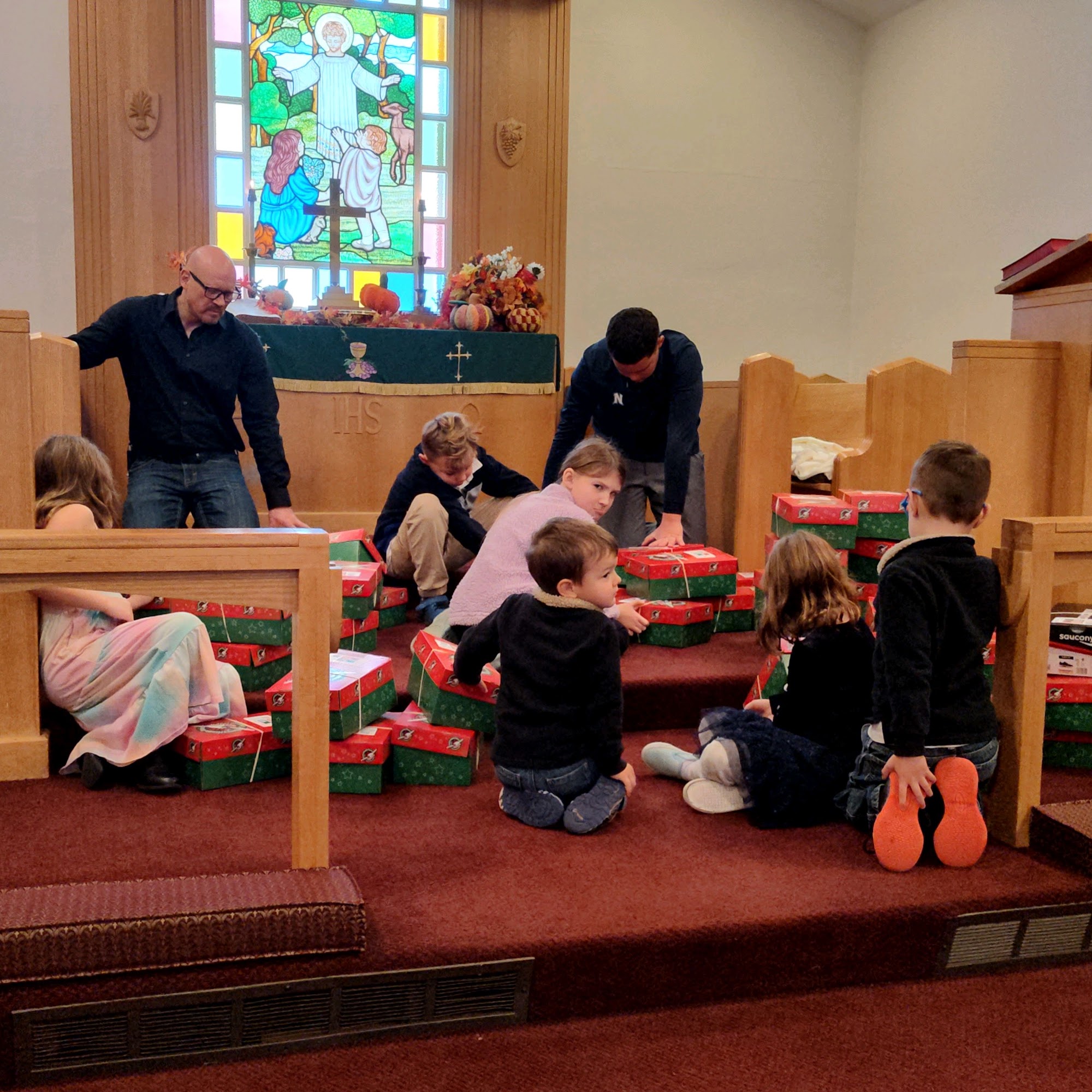 Children of the church filling Operation Christmas Child shoeboxes at the altar